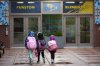 Three sisters, whose single mother fears being mistakenly detained by federal immigration agents because she is of Puerto Rican descent and speaks Spanish, walk into Funston Elementary School after being dropped off for the start of the school day, in Chicago's Logan Square neighborhood, Wednesday, Oct. 15, 2025. (AP Photo/Rebecca Blackwell)