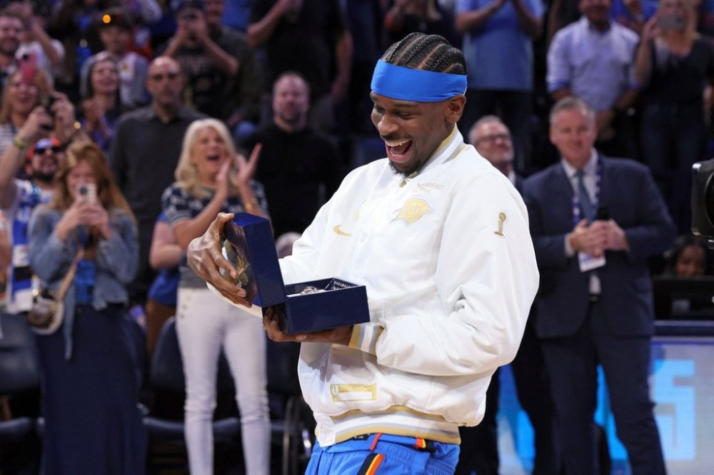 Oklahoma City Thunder guard Shai Gilgeous-Alexander looks at his championship ring during a ceremony before an NBA basketball game against the Houston Rockets Tuesday, Oct. 21, 2025, in Oklahoma City. (AP Photo/Nate Billings)