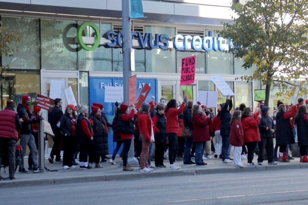 Striking Alberta teachers and supporters wave signs outside Rogers Place in Edmonton, on Thursday, Oct. 16, 2025. THE CANADIAN PRESS/Aaron Sousa