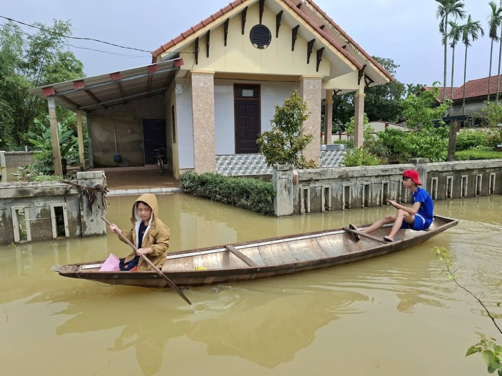Local residents paddle a boat through a flooded street in Hue, Vietnam, Friday, Oct. 31, 2025. (Mai Huyen Trang/VNA via AP)