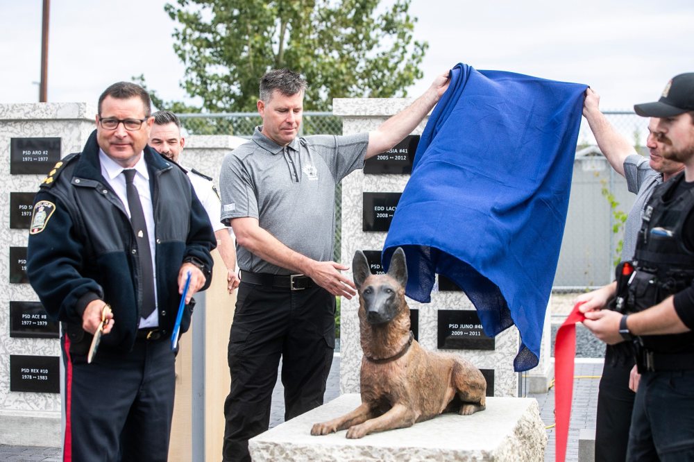 MIKAELA MACKENZIE / FREE PRESS Winnipeg Police Service Chief Gene Bowers (left) after cutting a ribbon at the canine unit memorial’s unveiling Wednesday.