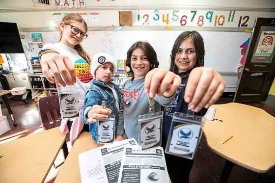 Earl Grey Press reporters, from left: Willow, James, Sebastian and Isabel with their press cards. (Mikaela MacKenzie / Free Press)