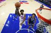 Philadelphia 76ers' Joel Embiid (21) goes up for a shot past Minnesota Timberwolves' Joan Beringer (19) during the first half of an preseason NBA basketball game Friday, Oct. 17, 2025, in Philadelphia. (AP Photo/Matt Slocum)
