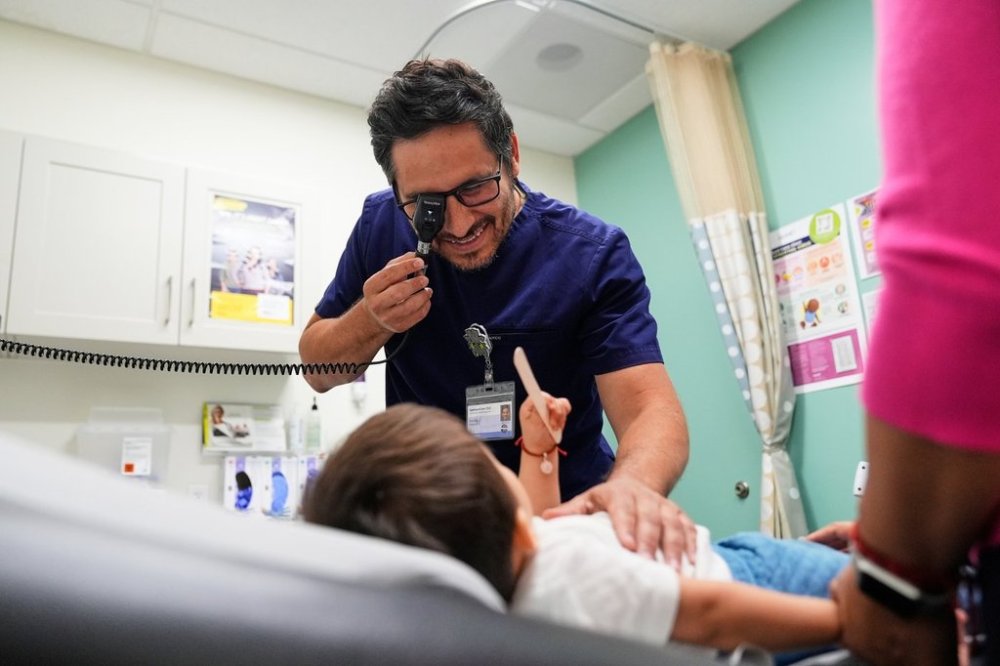 FILE - Pediatrician Irving Phillips, left, examines a 16-month-old boy at a CommuniCARE+OLE clinic, June 26, 2025, in Davis, Calif. (AP Photo/Godofredo A. Vásquez, File)