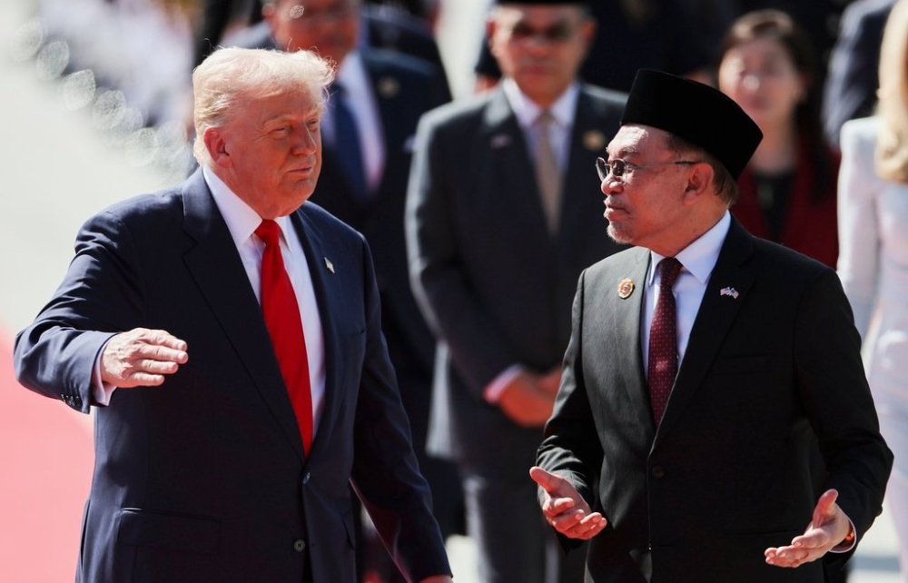 U.S. President Donald Trump talks with Malaysia Prime Minister Anwar Ibrahim as he arrives at Kuala Lumpur International Airport to attend the 47th Association of Southeast Asian Nations (ASEAN) summit in Kuala Lumpur, Malaysia, Sunday, Oct. 26, 2025. (Hasnoor Hussain/Pool Photo via AP)