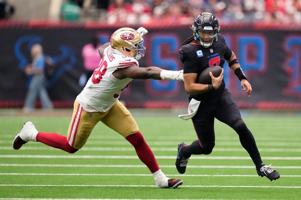 Houston Texans quarterback C.J. Stroud, right, runs with the ball as San Francisco 49ers defensive lineman Mykel Williams defends during the first half of an NFL football game Sunday, Oct. 26, 2025, in Houston. (AP Photo/Eric Christian Smith)