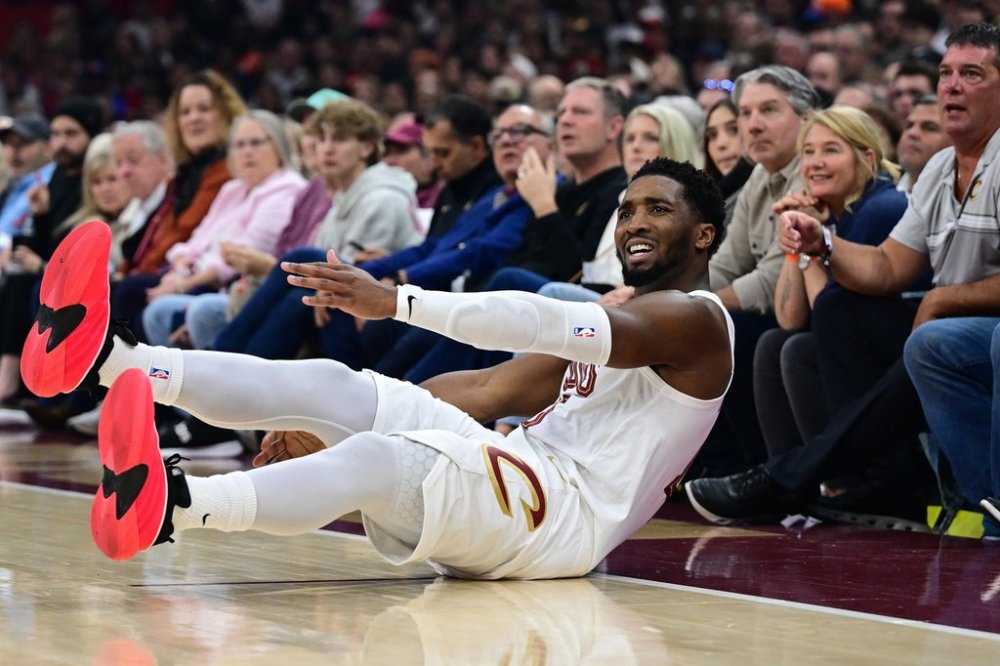 Cleveland Cavaliers guard Donovan Mitchell slides on the floor after being fouled on an attempted 3-point basket in the first half of an NBA basketball game against the Milwaukee Bucks, Sunday, Oct. 26, 2025, in Cleveland. (AP Photo/David Dermer)