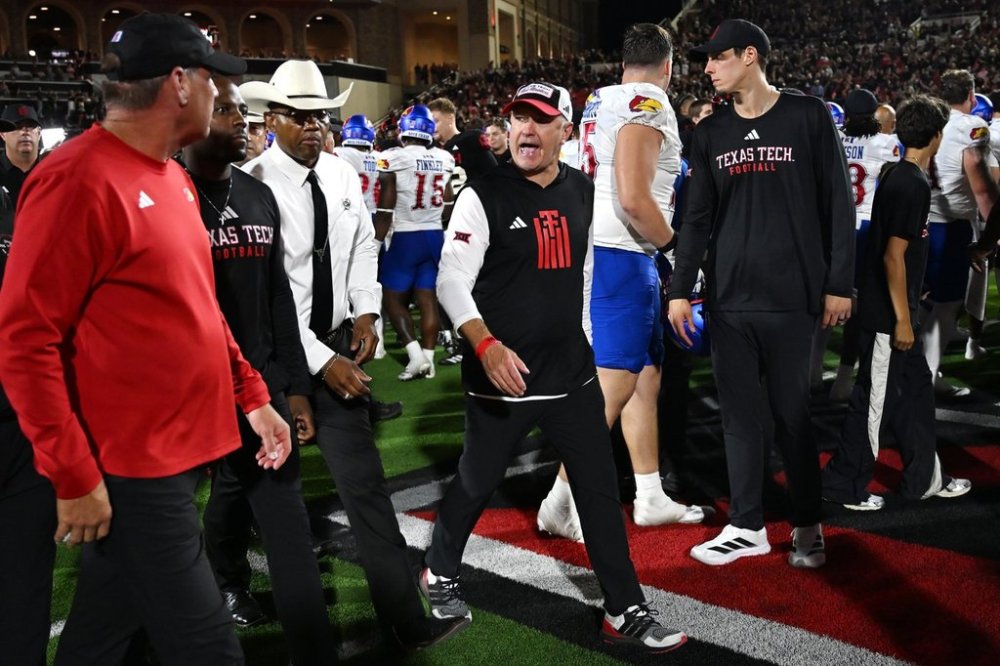 Texas Tech head coach Joey McGuire, center, speaks to Kansas head coach Lance Leipold, left, after the end of the NCAA college football game, Saturday, Oct. 11, 2025, in Lubbock, Texas. (AP Photo/Annie Rice)
