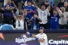 Toronto Blue Jays' Addison Barger watches his grand slam home run take flight as Los Angeles Dodgers' pitcher Anthony Banda, left, looks away uring the sixth inning in Game 1 of baseball's World Series, Friday, Oct. 24, 2025, in Toronto. (AP Photo/David J. Phillip)