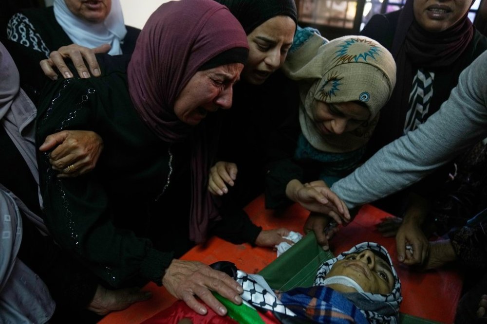 Wafa Hammad, 52, left, mother of Palestinian teen Yamen Hamed, 15 who was allegedly killed by the Israeli army during overnight clashes, cries while she takes the last look at his body during his funeral in the West Bank town of Silwad Friday, Oct. 31, 2025. (AP Photo/Nasser Nasser)