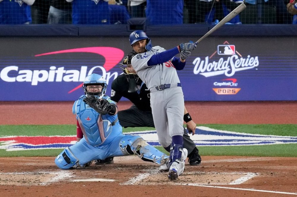 Los Angeles Dodgers' Mookie Betts follows through on his two run base hit against the Toronto Blue Jays during the third inning in Game 6 of baseball's World Series, Friday, Oct. 31, 2025, in Toronto. (AP Photo/Ashley Landis)