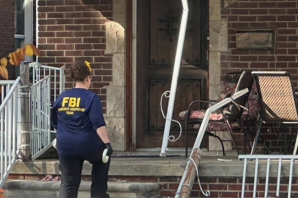 An FBI agent enters a home in a Dearborn, Mich., neighborhood on Friday, Oct. 31, 2025. (AP Photo/Mike Householder)