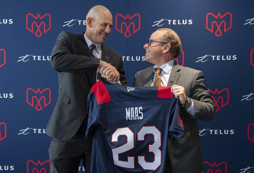 Jason Maas, left, shakes hands with Montreal Alouettes General Manager Danny Maciocia in Montreal, Tuesday, December 20, 2022, following a news conference announcing him as new head coach of the team. THE CANADIAN PRESS/Graham Hughes