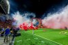 Smoke from flares thrown by fans fills the field before the soccer derby between Maccabi Tel Aviv and Hapoel Tel Aviv was called off Sunday after pregame disturbances led police to deem it unsafe to proceed at Bloomfield Stadium in Tel Aviv, Israel, Sunday, Oct. 19, 2025 . (AP Photo/Nir Keidar)
