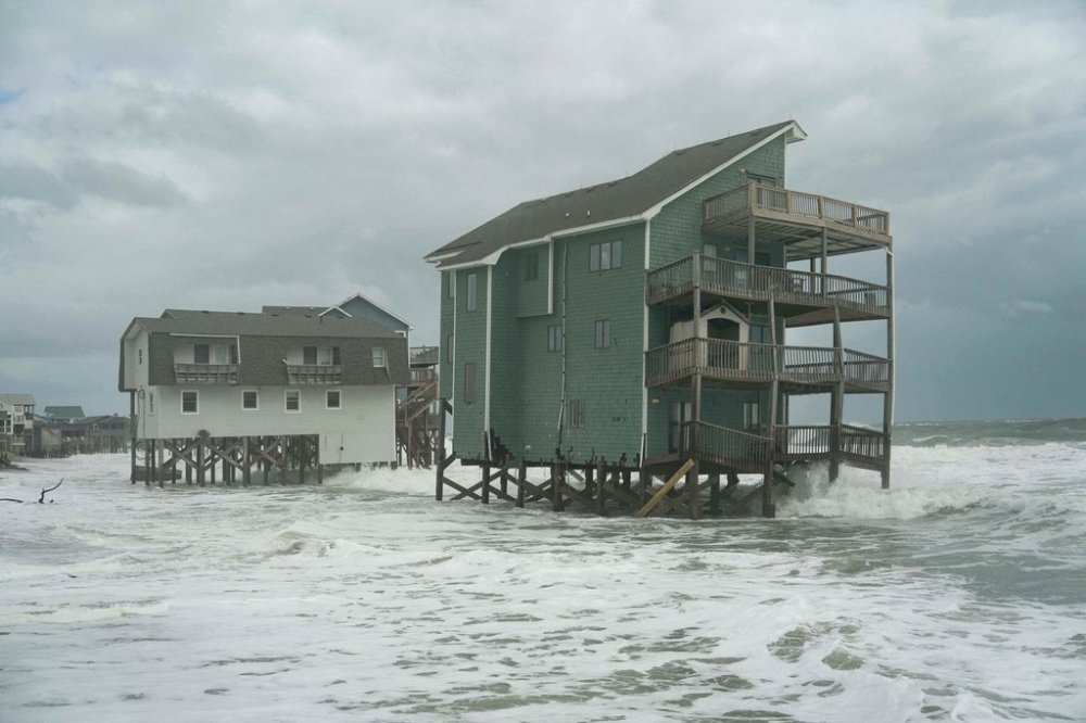 Homes at risk of falling into the ocean are visible as a storm approaches Friday, Oct. 10, 2025, in Buxton, N.C. (AP Photo/Allison Joyce)