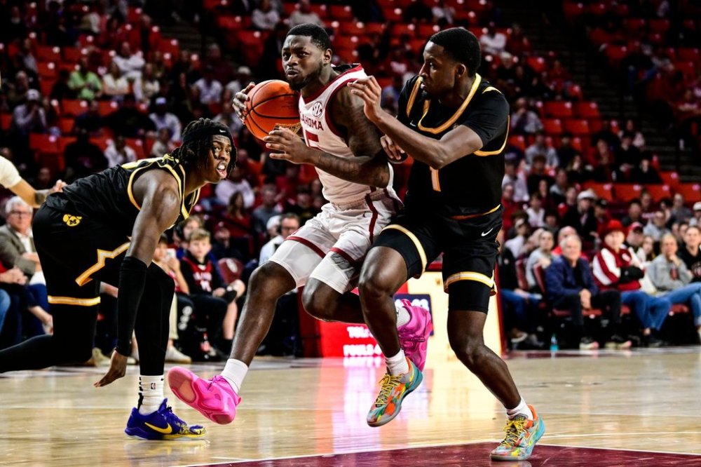 FILE - Oklahoma guard Duke Miles (15) drives against Missouri guard Marques Warrick (1) and Missouri guard Mark Mitchell (25) during the second half of an NCAA college basketball game, March. 5, 2025, in Norman, Okla. (AP Photo/Gerald Leong, File)