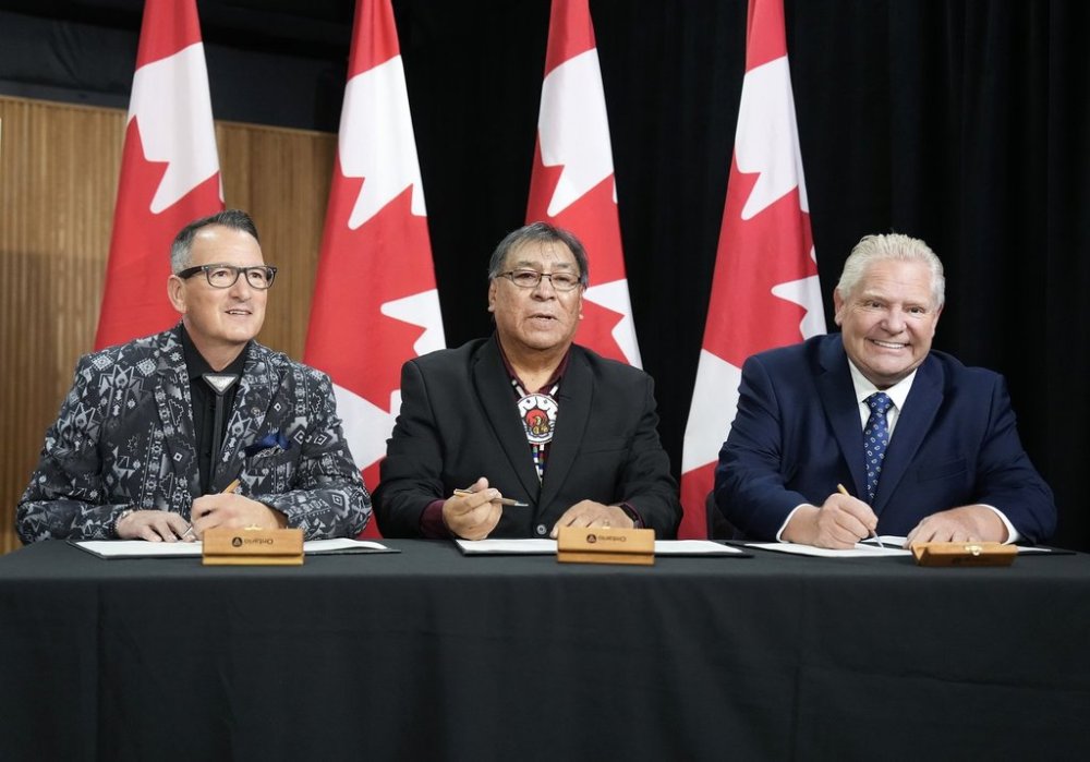 Ontario Premier Doug Ford, right, signs an agreement with Webequie First Nation Chief Cornelius Wabasse, centre, and Greg Rickford, Indigenous Affairs Minister at Queen's Park in Toronto on Wednesday, October 29, 2025. A northern Ontario First Nation has signed a partnership deal with the province designed to speed up construction of a road to the mineral-rich Ring of Fire. THE CANADIAN PRESS/Nathan Denette