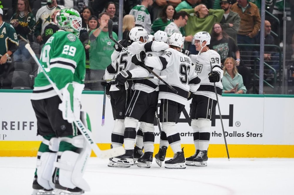 The Los Angeles Kings celebrate the winning goal by right wing Adrian Kempe (9) as Dallas Stars goaltender Jake Oettinger (29) skates off during overtime in an NHL hockey game Thursday, Oct. 23, 2025, in Dallas. (AP Photo/LM Otero)
