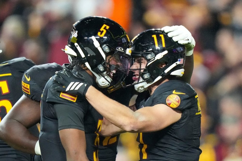 Washington Commanders quarterback Jayden Daniels, left, celebrates connecting with wide receiver Luke McCaffrey for a touchdown during the second half of an NFL football game against the Chicago Bears, Monday, Oct. 13, 2025, in Landover, Md.(AP Photo/Stephanie Scarbrough)