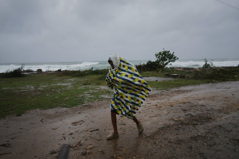 A man walks under the rain before the arrival of Hurricane Melissa in Canizo, a village in Santiago de Cuba, Tuesday, Oct. 28, 2025. (AP Photo/Ramón Espinosa)
