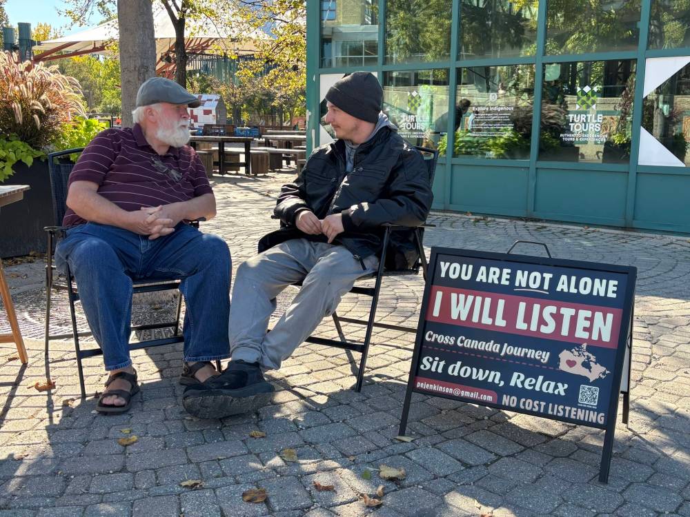 JOHN LONGHURST / FREE PRESS
                                Paul Jenkinson (left) listens to Maverick after setting up shop at The Forks last week in one of 600 conversations he’s had across Canada so far.