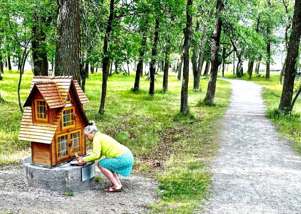 A little free library on Pinawa’s Ironwood Trail intrigues Margie Mackintosh.