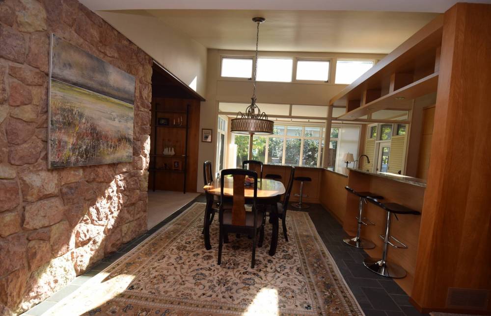 Mid-century modern and contemporary design details combine to create an impressive dining/kitchen area.