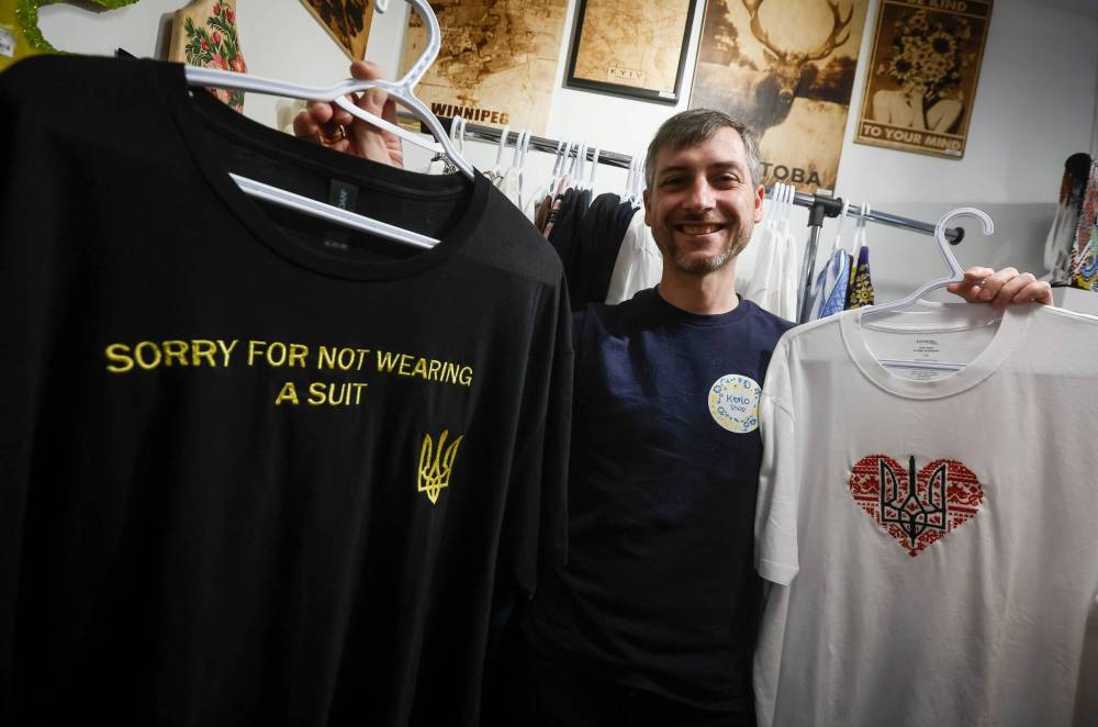 JOHN WOODS / FREE PRESS 
                                Serhii Okhrimenko, who works full-time for Canad Inns as an audio-visual technician, shows off some of the Ukrainian-themed T-shirts at Kolo Shop.