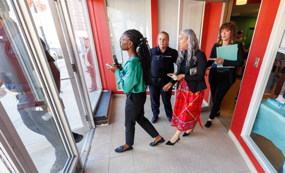 MIKE DEAL / FREE PRESS
Two officers with the provincial protective services escort Minister Nahanni Fontaine as she leaves 510 Selkirk St., which will be the location of Mino’Ayaawag Ikwewag Lodge.