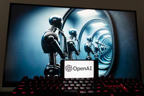 The OpenAI logo is displayed on a cellphone with an image on a computer screen generated by ChatGPT’s Dall-E text-to-image model (Michael Dwyer / The Associated Press files)