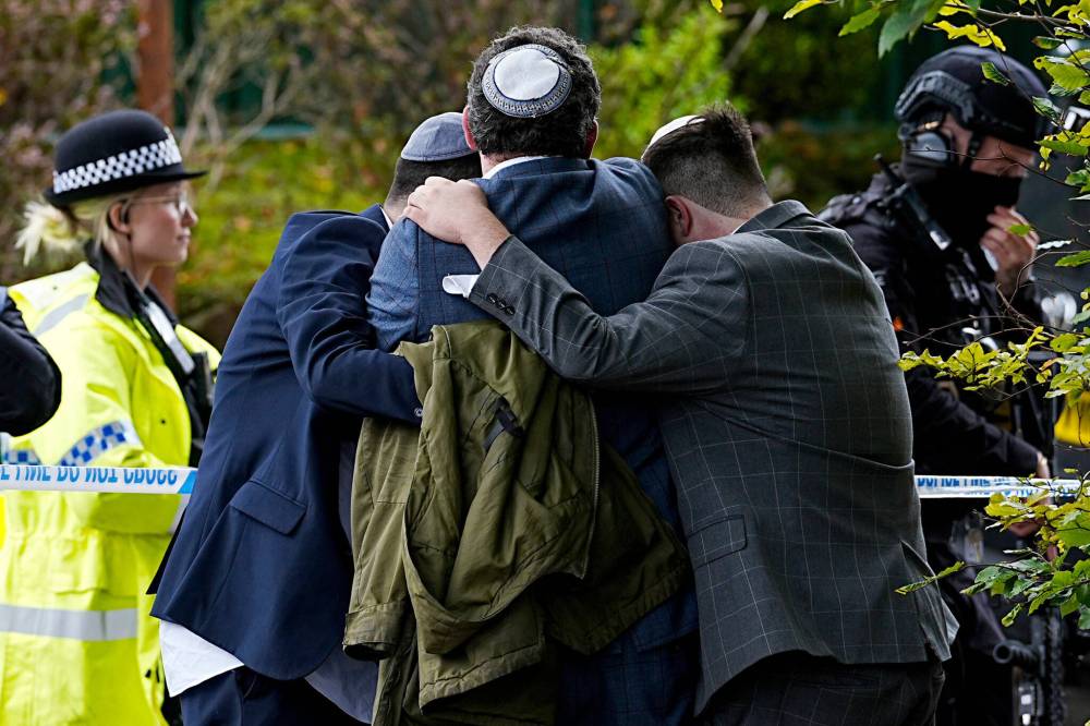 Peter Byrne/PA via AP
Members of the Jewish community comfort each other near the Heaton Park Hebrew Congregation synagogue, after an attack on Yom Kippur.