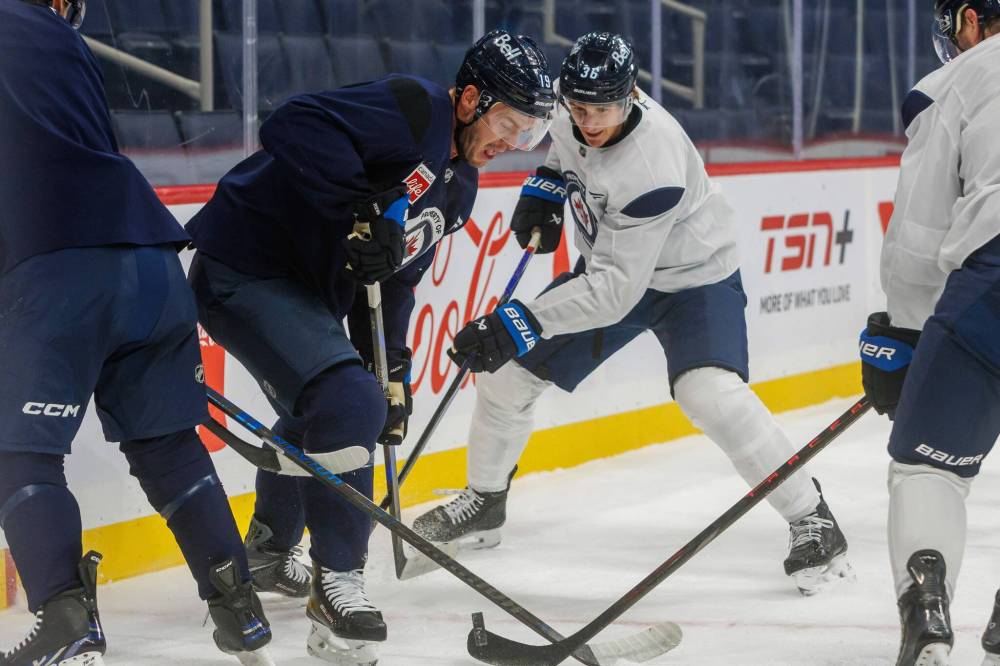 MIKE DEAL / FREE PRESS
Winnipeg Jets forwards Jonathan Toews (left) and Morgan Barron battle for the puck during practice at Canada Life Centre on Tuesday. Toews is still eligible to be added to the active roster if he makes it through Wednesday’s practice without any setbacks.