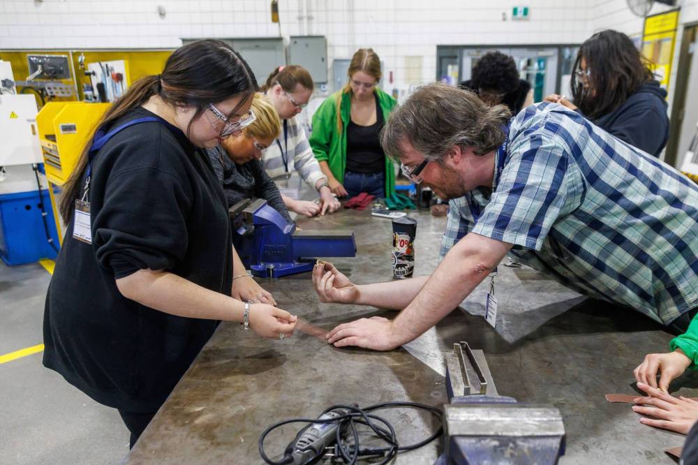 MIKE DEAL / FREE PRESS
Autumnlee (left) shows Patrick Taggart, instructional assistant in the industrial mechanic/millwright program her progress making a brass ring on Wednesday in Winnipeg.