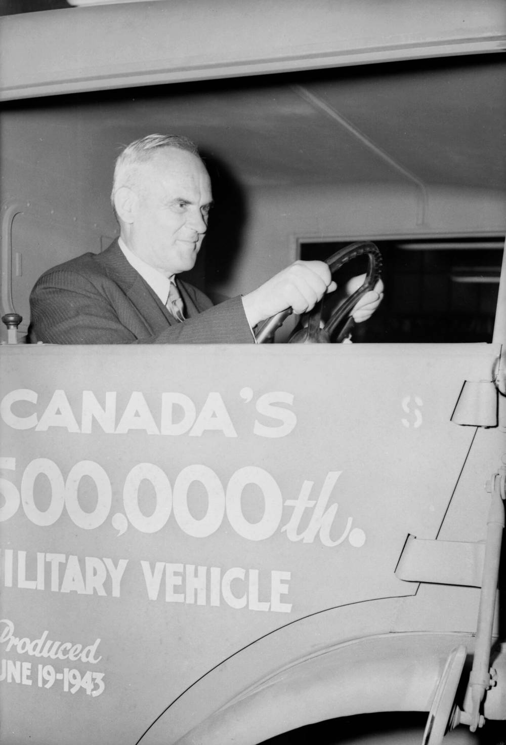 National Film Board of Canada / Library and Archives Canada
C.D. Howe gets the feel of things by taking hold of a steering wheel during ceremonies on June 19, 1943, that marked the delivery of the half-millionth unit of motorized equipment produced in Canada during the Second World War.