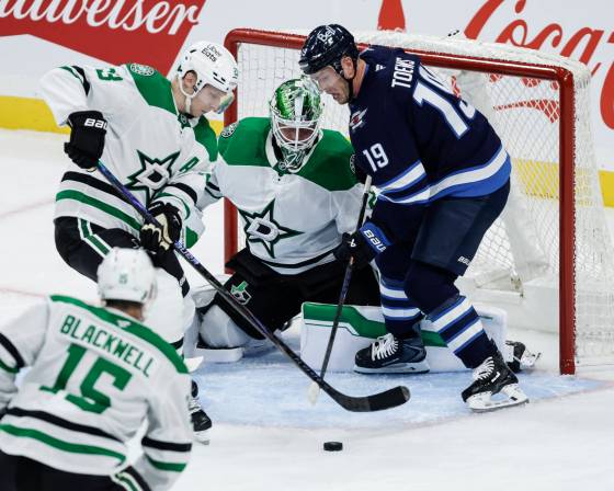 Esa Lindell (23) and goaltender Jake Oettinger defend against Winnipeg Jets’ Jonathan Toews in Winnipeg on Thursday. (John Woods / The Canadian Press files)