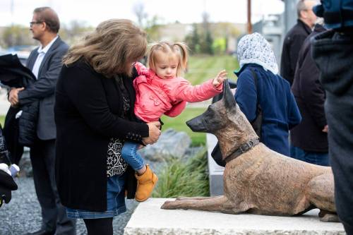 MIKAELA MACKENZIE / FREE PRESS
                                Two-year-old Eva Reinus and her grandmother Judy Tyndall check out the new memorial outside of the canine unit kennels on Durand Street on Wednesday.