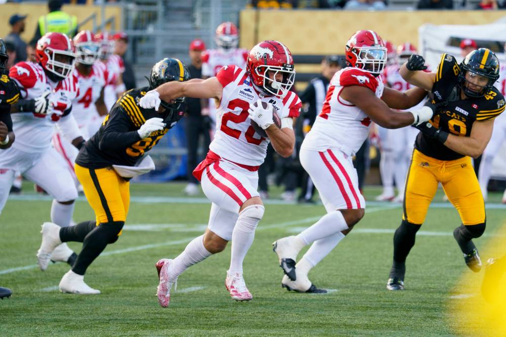 Peter Power / THE CANADIAN PRESS
Calgary Stampeders’ Ludovick Choquette (28) runs in for a touchdown against the Hamilton Tiger-Cats Saturday. The Stamps are showing signs of life after slumping in the second half of the season.