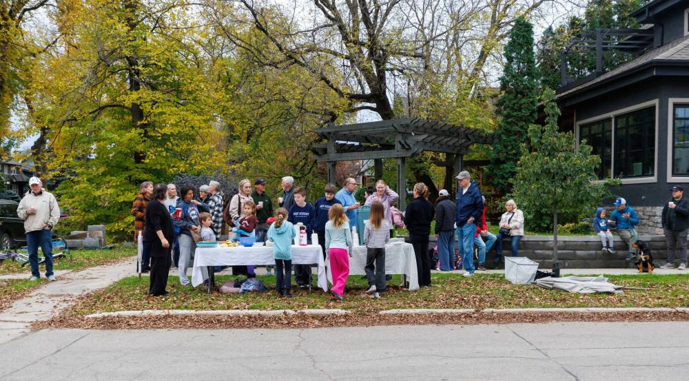 MIKE DEAL / FREE PRESS
A crowd of neighbours and parents of school kids chat after getting a drink at the coffee stand run by nine-year-old Annie MacDonald every Thursday to raise money for CancerCare Manitoba.