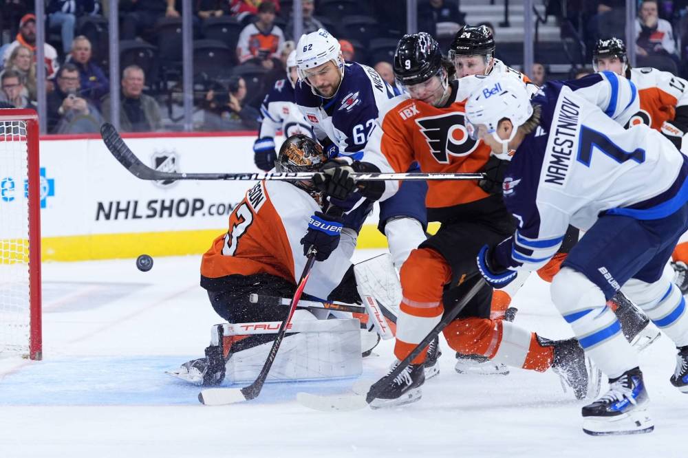 Matt Slocum / The Associated Press
Vlad Namestnikov (right) notches the Jets’ first goal against the Flyers with a shot through a crowd Thursday night in Philadelphia.