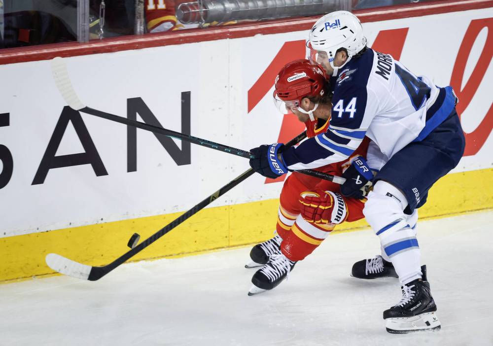 Jeff McIntosh / THE CANADIAN PRESS
Winnipeg Jets’ Josh Morrissey, right, checks Calgary Flames’ Blake Coleman in the first period.
