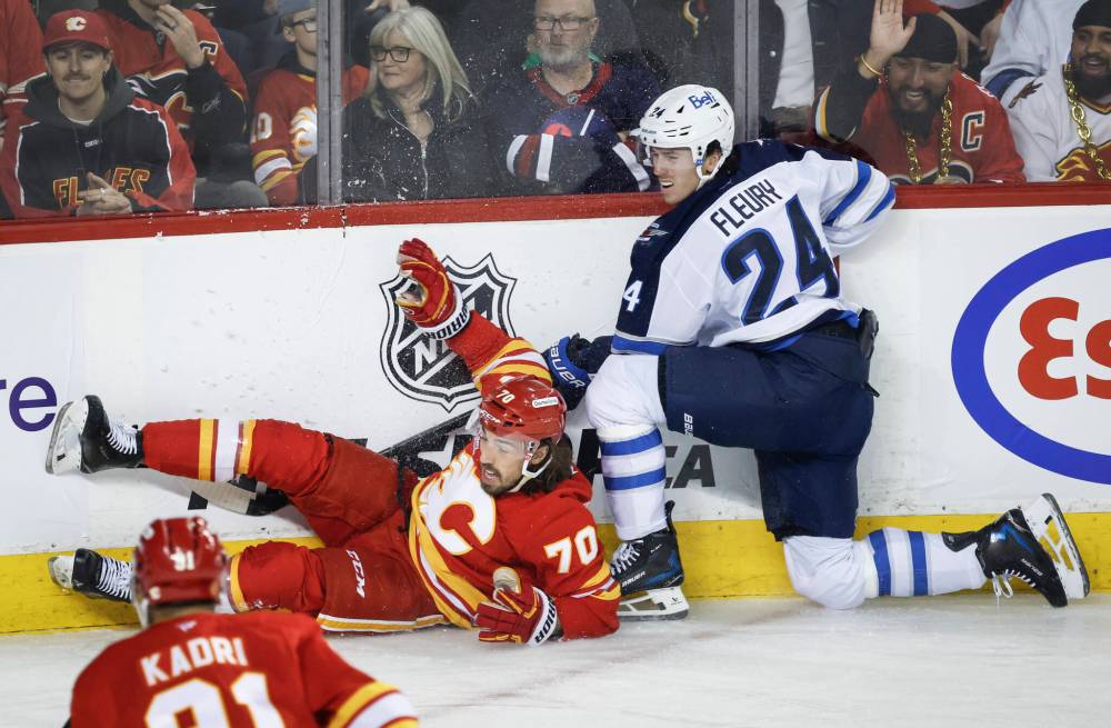 Jeff McIntosh / THE CANADIAN PRESS
Winnipeg Jets’ Haydn Fleury, right, collides with Calgary Flames’ Ryan Lomberg in the first period.