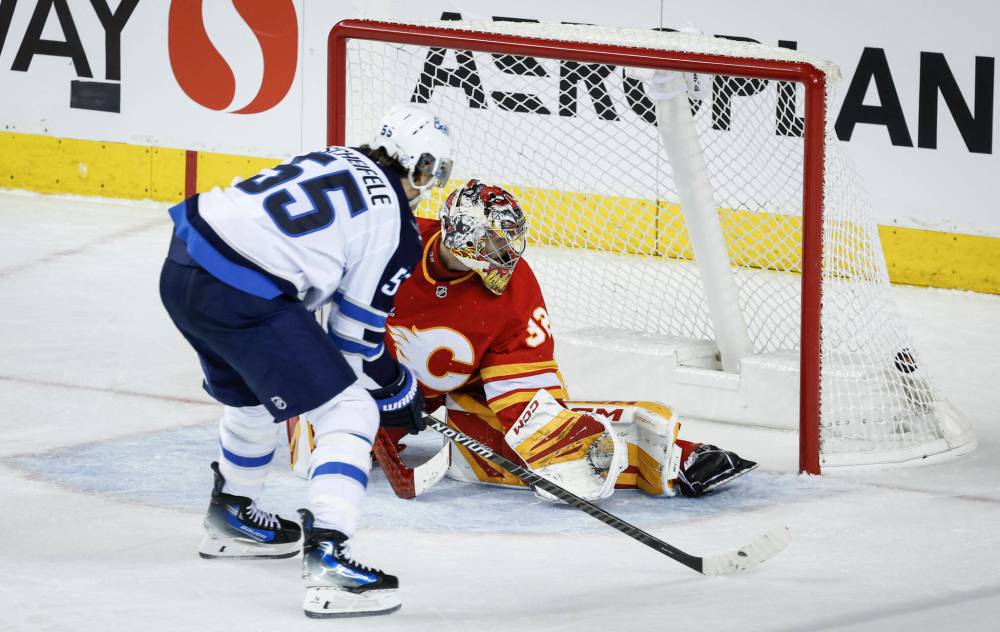 Jeff McIntosh / THE CANADIAN PRESS
Winnipeg Jets’ Mark Scheifele scores the game-winning goal on Calgary Flames goalie Dustin Wolf in the third period.