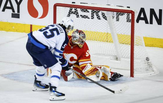 Winnipeg Jets’ Mark Scheifele scores the game-winning goal on Calgary Flames goalie Dustin Wolf in the third period of Monday's game. (Jeff McIntosh / The Canadian Press)