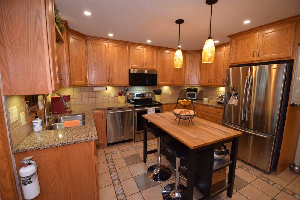 TODD LEWYS / FREE PRESS
                                The upgraded kitchen offers a tile floor, island, tons of oak cabinets, tile backsplash, granite countertops and stainless-steel appliances.