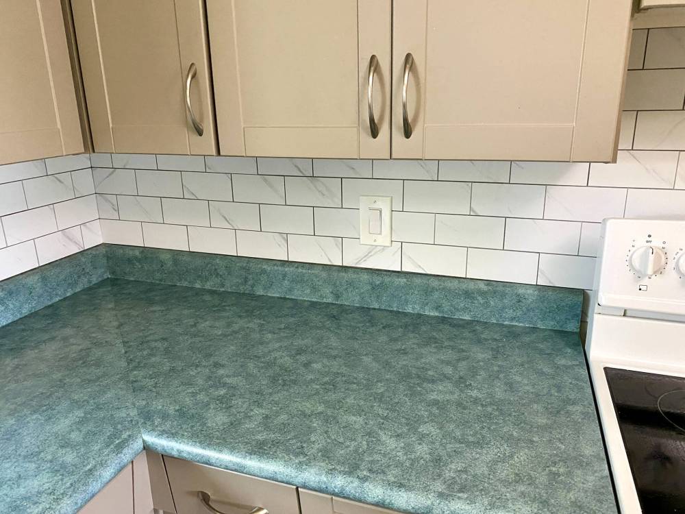 The tile mosaic is cut using a mitre saw, table saw and oscillating tool to meet the wall dimensions, and cater to outlet and switch locations.