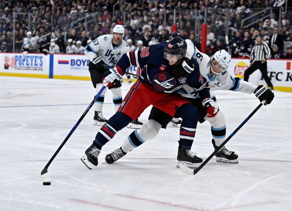 Winnipeg Jets’ Morgan Barron (36) tries to keep possession of the puck as Utah Mammoth John Marino (6) defends during the second period. (Fred Greenslade / The Canadian Press)