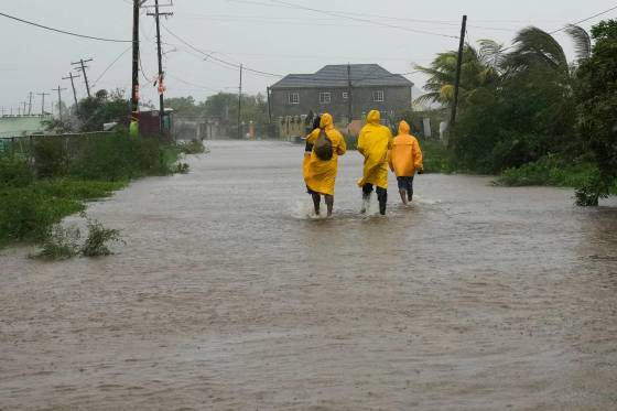 People walk along a road during the passing of Hurricane Melissa in Rocky Point, Jamaica, Tuesday. (Matias Delacroix / The Associated Press)