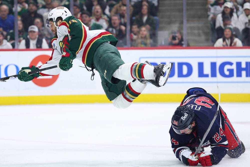 Matt Krohn / The Associated Press
                                Minnesota Wild forward Vinnie Hinostroza, left, flies over Winnipeg Jets defenceman Haydn Fleury in the first period.
