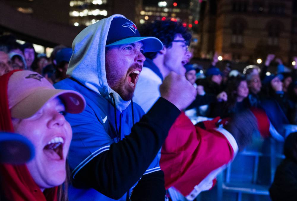 Laura Proctor / The Canadian Press
                                Toronto Blue Jays fans react as the team plays against the Los Angeles Dodgers at a watch party at Nathan Phillips Square in Toronto Friday.