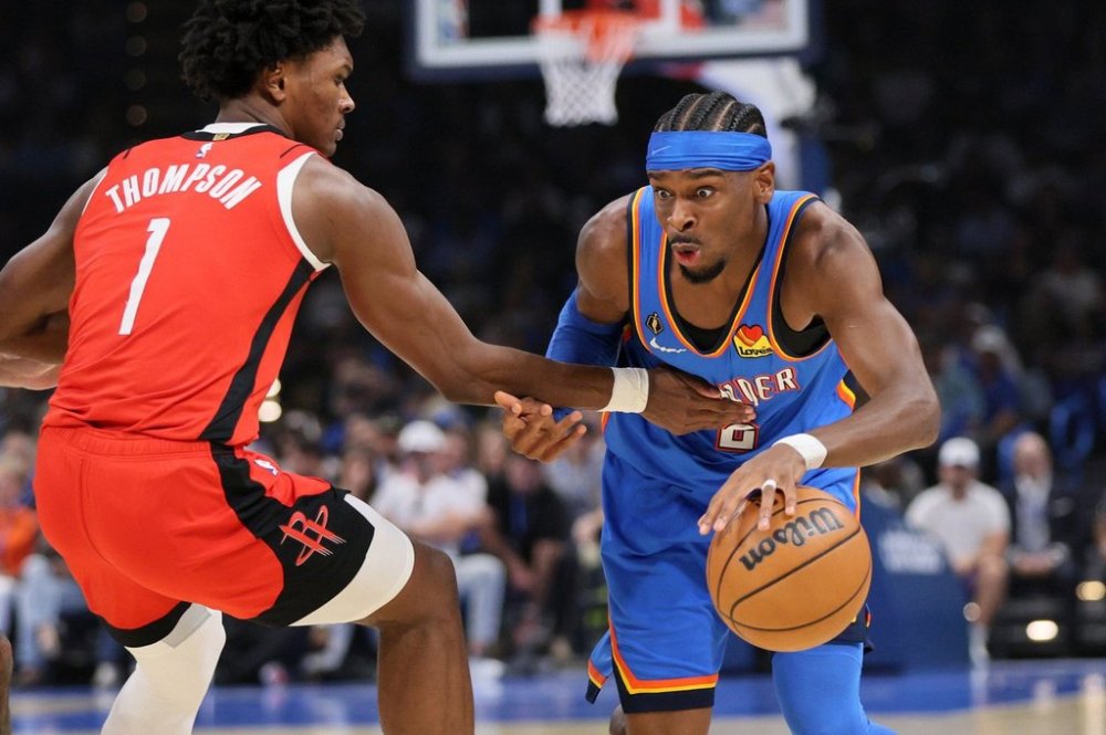Oklahoma City Thunder guard Shai Gilgeous-Alexander, right, drives against Houston Rockets guard Amen Thompson (1) during the first half of an NBA basketball game Tuesday, Oct. 21, 2025, in Oklahoma City. (AP Photo/Nate Billings)